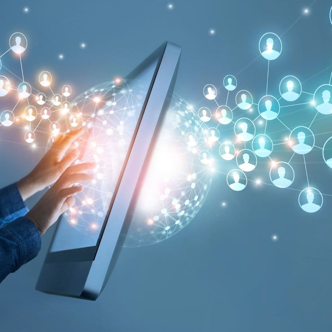A hand touching a computer screen as glowing network nodes representing customer data connect across it.
