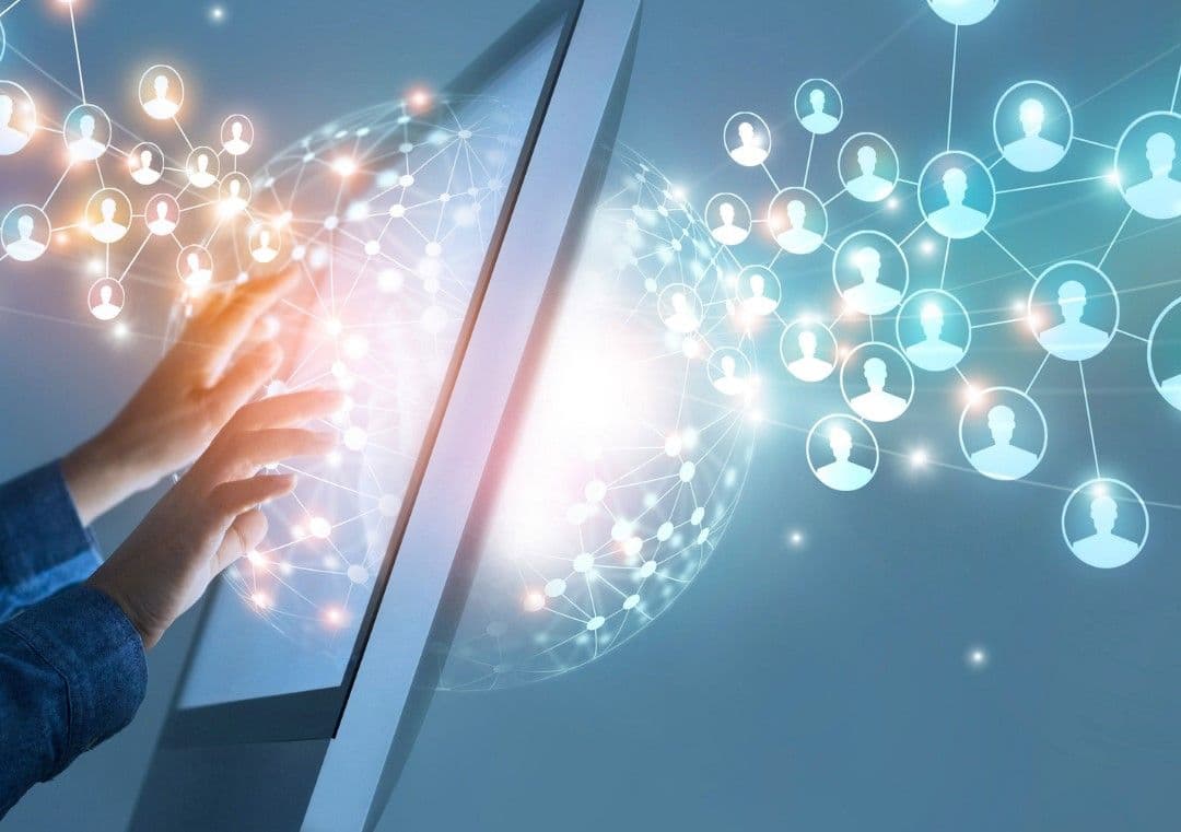 A person reaching toward a screen surrounded by interconnected user icons, illustrating how a business collects and shares customer data.