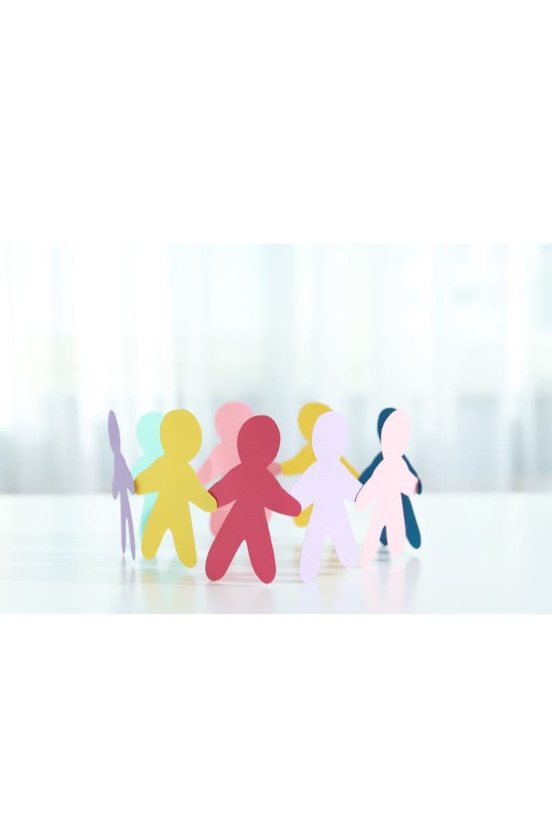 Colorful paper cutout figures of people standing together in a circle, representing a diverse team.